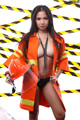 A woman in an orange jacket holding a hard hat.