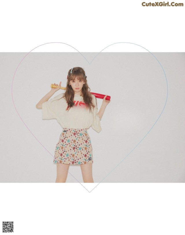 A woman holding a baseball bat in front of a heart.
