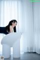 A woman sitting on top of a white chair.