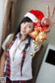 A woman in a santa hat holding up a bell.