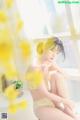 A woman in a yellow lingerie sitting on a window sill.
