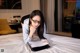 A woman laying on a bed with a pen and paper.