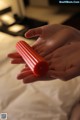 A person holding a red object in their hand.