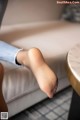 A woman's bare feet sitting on a couch.