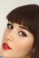 A close up of a woman with long brown hair and red lipstick.